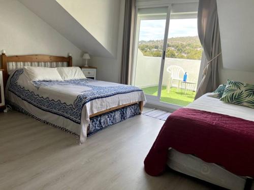 a bedroom with two beds and a large window at Duplex en résidence privée, piscine, vue mer panoramique in Alcossebre