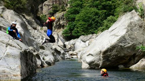 a group of people jumping off of rocks into a river at Villa Les Romarins in Vallon-Pont-dʼArc