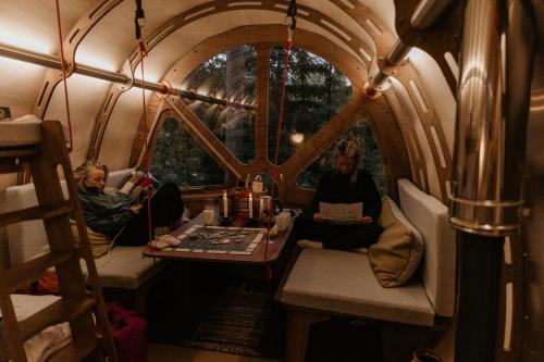 two people sitting at a table in a train room at Näsets Marcusgård in Furudal