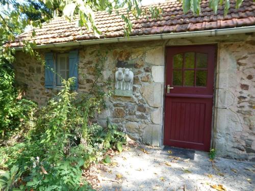 Casa de piedra con puerta roja y ventana en La Maison du Berger de La Chassagne, 