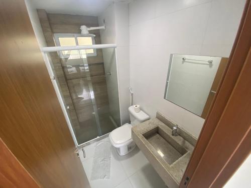 ein Badezimmer mit einem WC, einem Waschbecken und einem Spiegel in der Unterkunft SOLAR DE PORTO RICO "Aptms" P GALINHAS in Porto De Galinhas