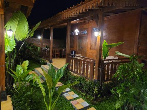 a wooden cabin with a porch at night at La Tavisa Hotel Borobudur in Magelang