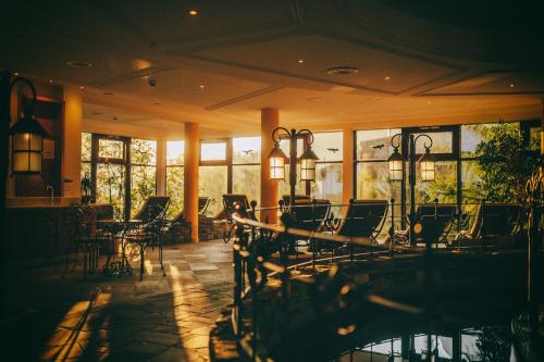 a lobby with chairs and tables and windows at Wellnesshotel Warther Hof in Warth am Arlberg