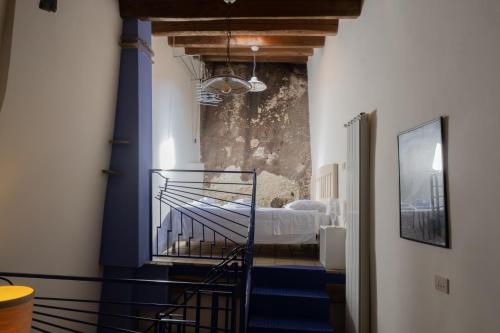 B&B Dimora Cigno في بييترابيرتوسا: ممر مع سرير في غرفة بجدران زرقاء