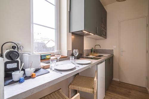une cuisine avec un comptoir et des verres de vin dans l'établissement Le Sérénité - Studio Cocon à deux pas de la gare, à Reims