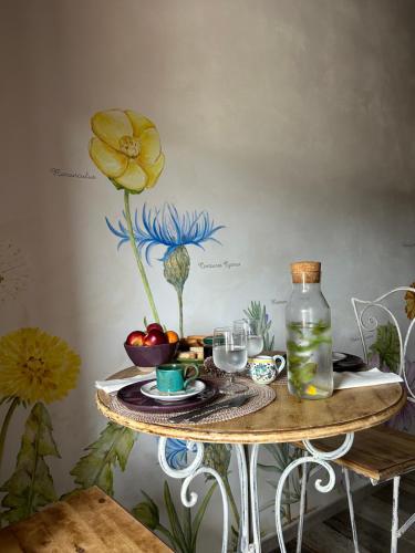 una mesa con una flor pintada en la pared en OlioeAlloro nel Borgo, en Campiglia Marittima