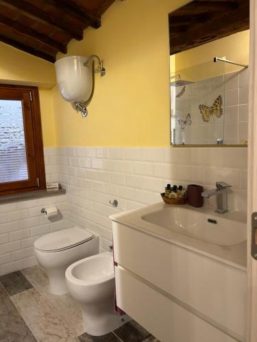 y baño con aseo blanco y lavamanos. en OlioeAlloro nel Borgo, en Campiglia Marittima