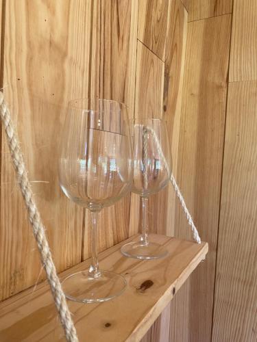 deux verres à vin assis sur une étagère en bois dans l'établissement L’Escargoterie de la Forge - Immersion Champêtre, à Uzemain