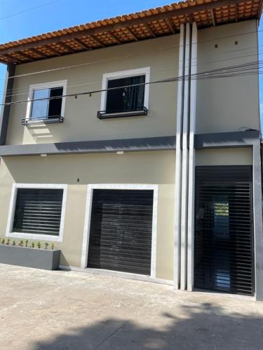 a house with two garage doors in front of it at Morada da Ilha Pousada in Soure
