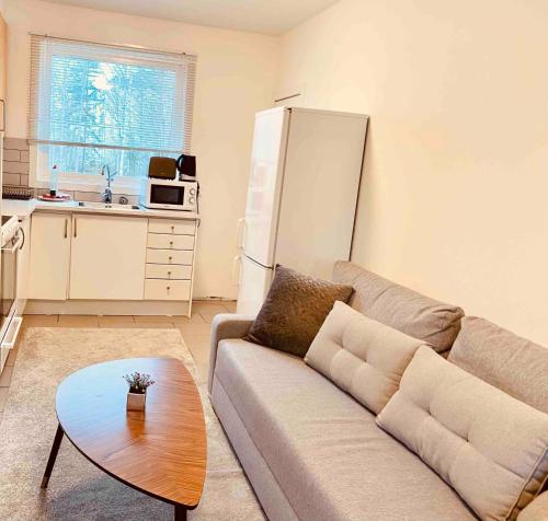 a living room with a couch and a table at Lovely 2-bed Flat In Stockholm in Sollentuna