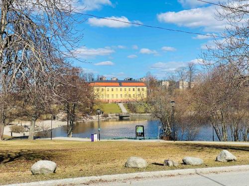 a building next to a lake with a building at Lovely 2-bed Flat In Stockholm in Sollentuna