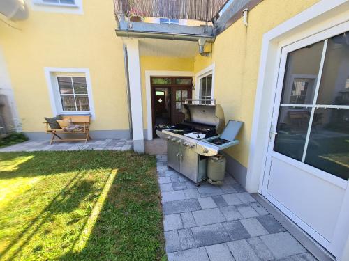 a backyard patio with a grill and a house at Rosenzauber Gipfelstürmer in Weißenstadt