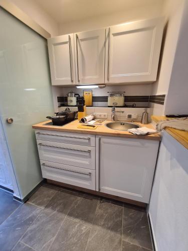 a kitchen with white cabinets and a sink at Rosenzauber Kraxler Pärchen in Weißenstadt