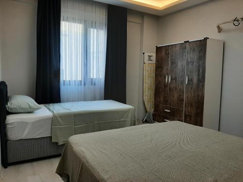 a hotel room with two beds and a window at Unuvar home in Kusadası
