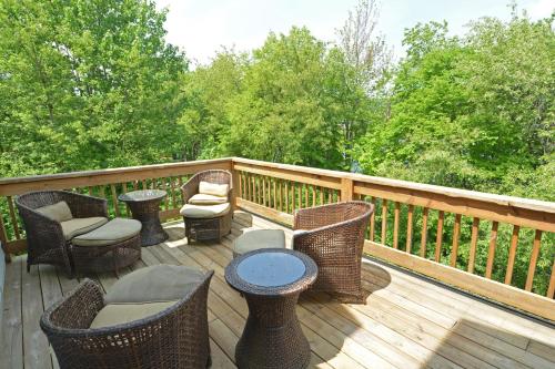 a deck with wicker chairs and chairs and a table at Duck Cove at Wisp in McHenry