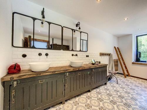 a bathroom with two sinks and a large mirror at Villa Wapiti in Aywaille