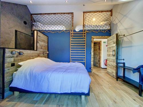 1 dormitorio con cama y pared azul en Villa Wapiti, en Aywaille