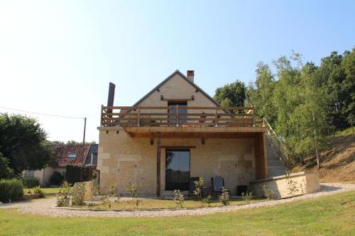 a house with a deck on top of it at Gîte de la Forge, le Grenier in Fléré-la-Rivière