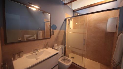 łazienka z umywalką, toaletą i lustrem w obiekcie Apartamento Naturaleza w mieście Mosqueruela
