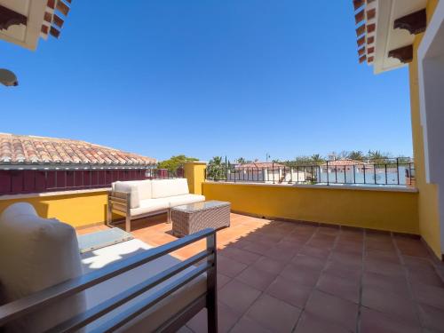 a balcony with a couch and a chair on a roof at Villa Sam 3 Bedroom Villa in Mar Menor Golf in Murcia