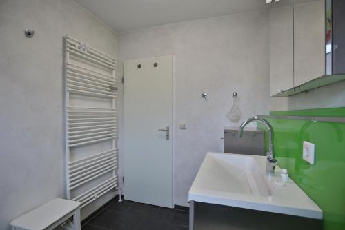 ein weißes Badezimmer mit Waschbecken und Dusche in der Unterkunft Am Rosenhain 6 Am Rosenhain 6 Appartement 5 in Timmendorfer Strand