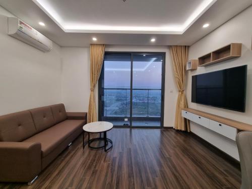 sala de estar con sofá y TV de pantalla plana en Homestay hoàng huy grand tower sở dầu hồng bàng hải phòng, en Hai Phong