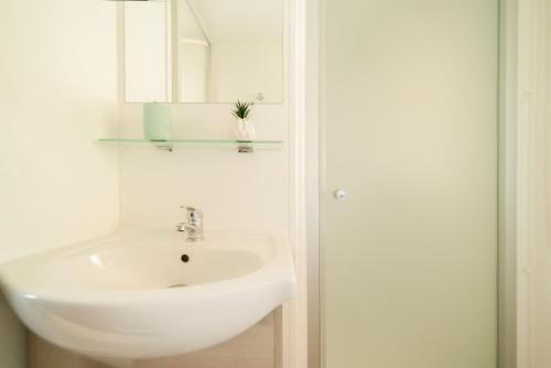 un baño con lavabo y espejo en Mobil Home les pieds dans l'eau, en Canet-en-Roussillon