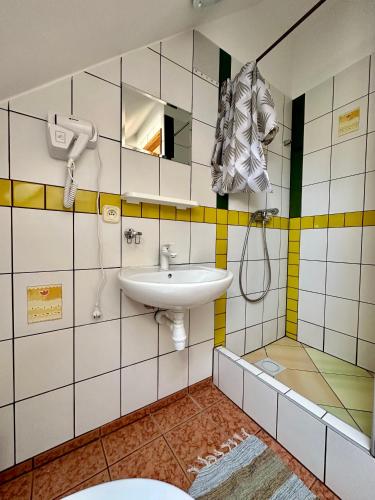 a bathroom with a sink and a shower at Leniwy Kot in Stegna
