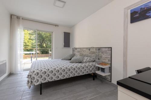 a white bedroom with a bed and a window at Etchetao in Boucau