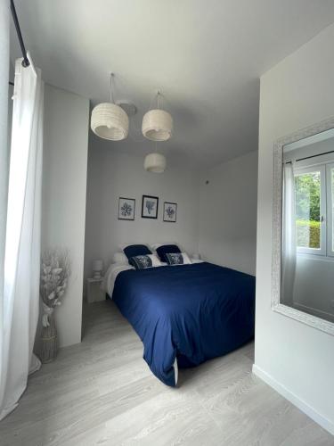 une chambre avec un lit avec des draps bleus et une fenêtre dans l'établissement Pti gîte chez sabine, à Labastide-du-Temple