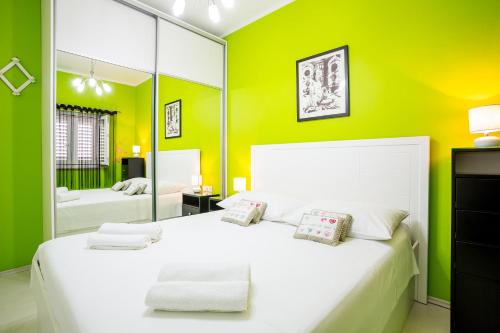 a bedroom with a white bed and a mirror at Apartments Biserka in Bol