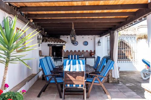 a patio with blue chairs and a wooden table at Pasa Fina, luxury holiday retreat in Villanueva del Trabuco