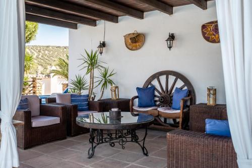 a patio with couches and chairs and a table at Pasa Fina, luxury holiday retreat in Villanueva del Trabuco