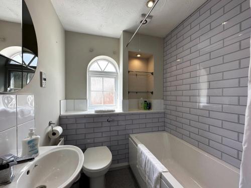a bathroom with a tub and a toilet and a sink at Layla's Place in Hertfordshire in Chesfield
