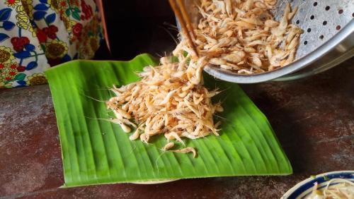 a pile of food on a green plate on a table at Ba Danh Homestay & Kitchen - Ben Tre Mekong in Ben Tre