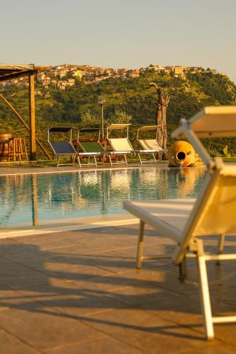 a pool with chairs and a giraffe in the background at L' Aia Resort in Trentinara
