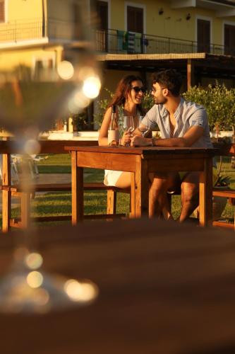 a man and a woman sitting at a picnic table at L' Aia Resort in Trentinara