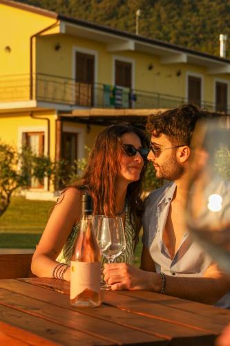 a man and woman sitting at a table with a bottle of wine at L' Aia Resort in Trentinara