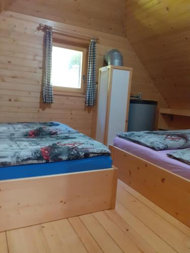 a bedroom with two beds in a log cabin at Brunarica na Goreljeku in Bohinj