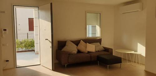 een woonkamer met een bank en een spiegel bij Claudia Apartment Peschiera in Peschiera del Garda
