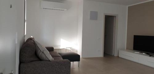 een woonkamer met een bank en een televisie bij Claudia Apartment Peschiera in Peschiera del Garda
