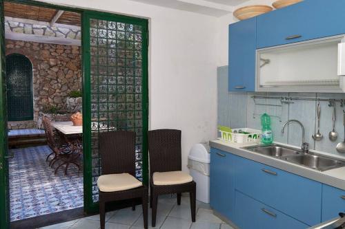 a kitchen with blue cabinets and a sink and a table at Villa La Sosta in Capri