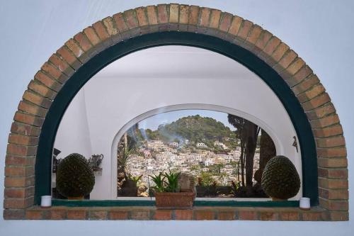 カプリにあるVilla La Sostaの市街の景色を望むアーチ型の窓
