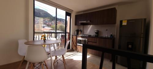 a kitchen with a table and chairs and a window at New Comfortable Apartments in La Candelaria, Bogotá in Bogotá