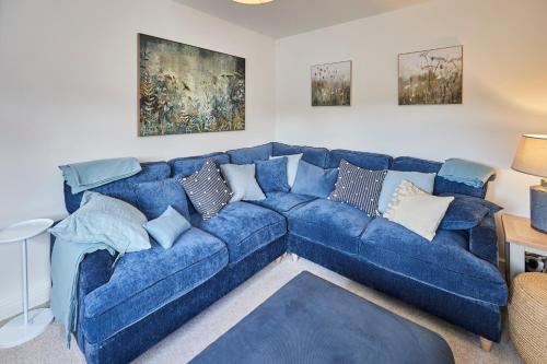 Host & Stay - Clackgill Cottage في Middlesmoor: أريكة زرقاء مع الوسائد في غرفة المعيشة