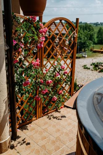 a wooden gate with pink flowers on it at Przy Trójstyku in Dubeninki