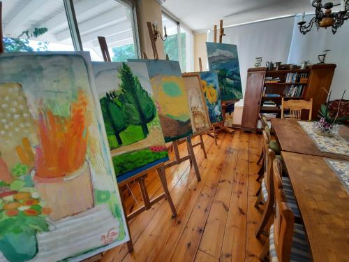 a room full of paintings on easels at Ha'Seuda Ha'Achrona Suites in Amirim