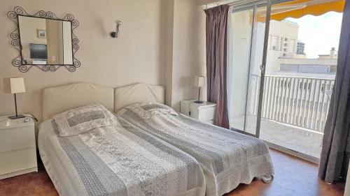 une chambre avec un lit et un balcon dans l'établissement Palais de la Mer, à Sainte-Maxime