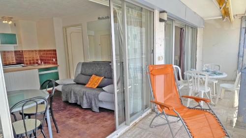 - un salon avec une chaise orange et un canapé dans l'établissement Palais de la Mer, à Sainte-Maxime