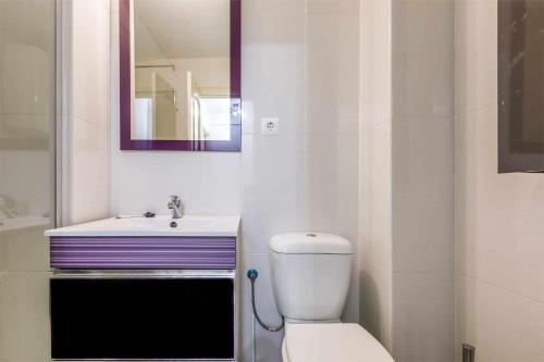 a bathroom with a toilet and a sink and a mirror at A&N Nevada 76 in Torre del Mar